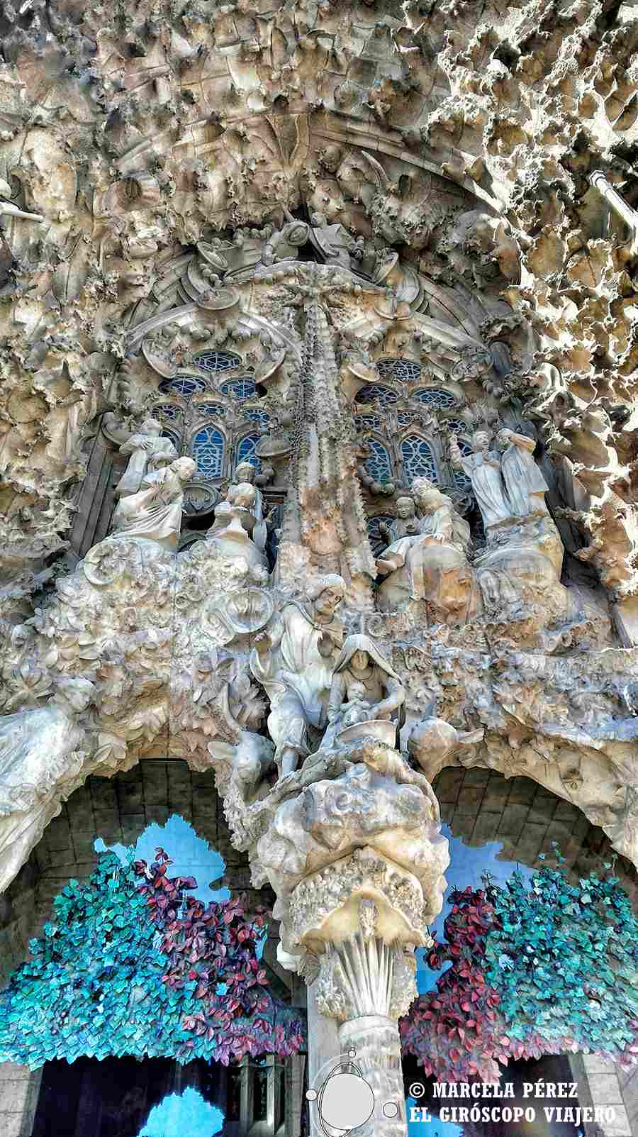 Puerta de acceso principal de la Sagrada Familia decorada con hojas en tonalidades primaverales y otoñales